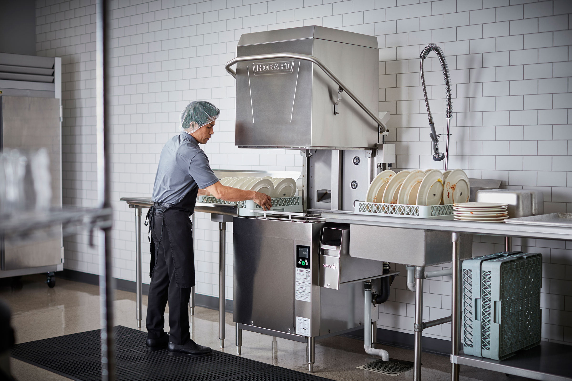 Commercial pass-through dishwasher in use in a professional kitchen